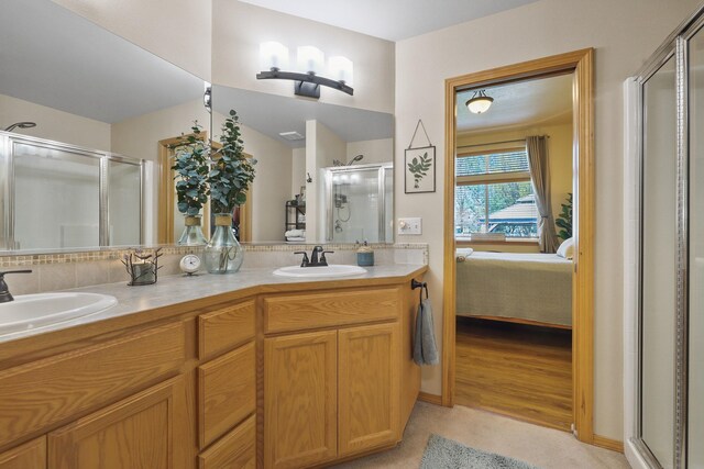 ensuite bathroom featuring a shower stall, ensuite bath, a sink, and double vanity