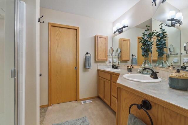 bathroom with baseboards, a sink, visible vents, and double vanity