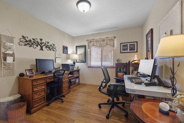 home office featuring wood finished floors and baseboards