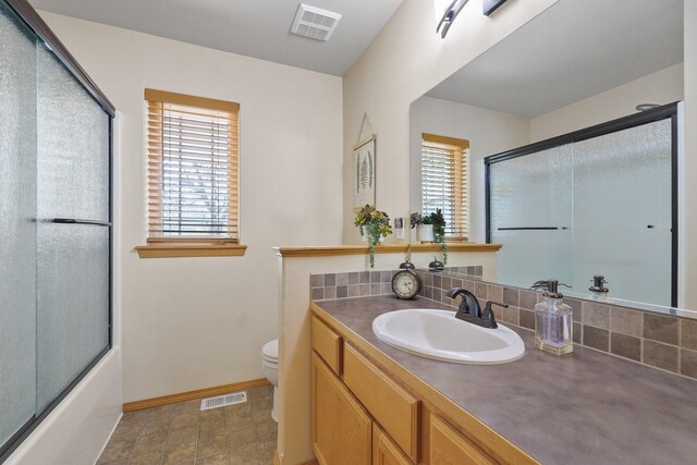 bathroom with toilet, visible vents, and a healthy amount of sunlight