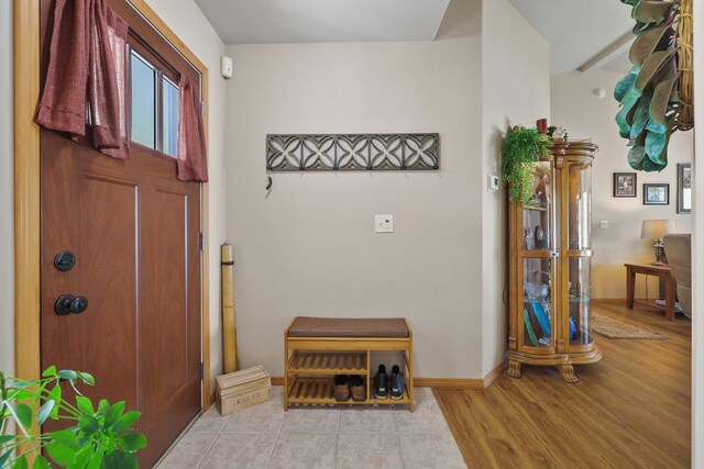 foyer entrance with baseboards and light wood-type flooring