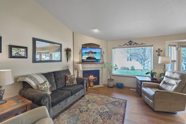 living area featuring a tile fireplace and wood finished floors