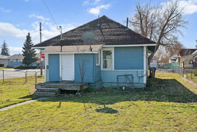 back of house featuring a lawn and fence