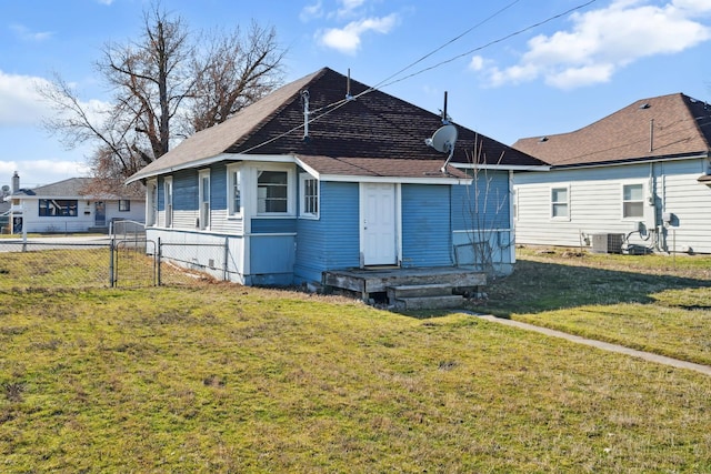 rear view of house featuring a gate, central air condition unit, a lawn, fence, and roof with shingles