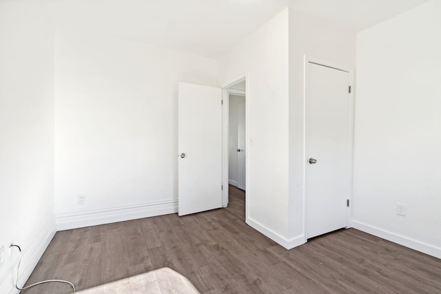 unfurnished room with baseboards and wood finished floors