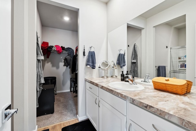 18706 E Flat Rock River Ave, Spokane Valley, WA 99016 - bathroom featuring baseboards, an enclosed shower, wood finished floors, vanity, and a walk in closet