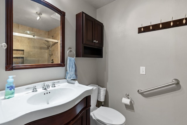 full bathroom with toilet, vanity, and a stall shower