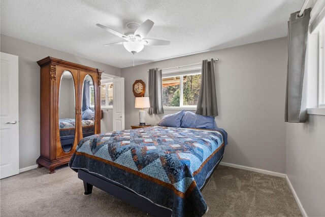carpeted bedroom featuring a ceiling fan, baseboards, and a textured ceiling