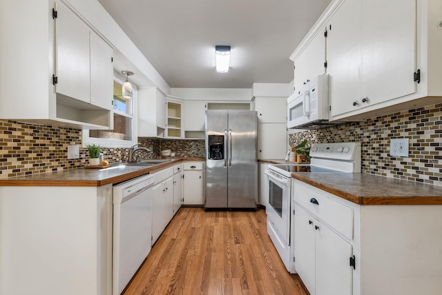 kitchen featuring light wood-style flooring, white appliances, and tasteful backsplash