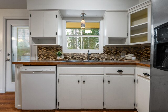 kitchen with white cabinets, white dishwasher, a sink, and tasteful backsplash