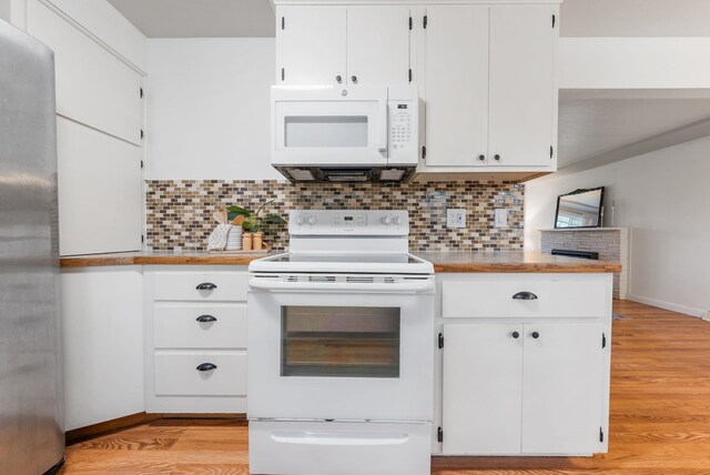 kitchen with light countertops, backsplash, and white appliances