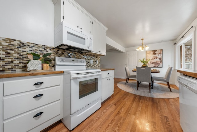 kitchen featuring light wood-type flooring, an inviting chandelier, backsplash, white cabinetry, and white appliances