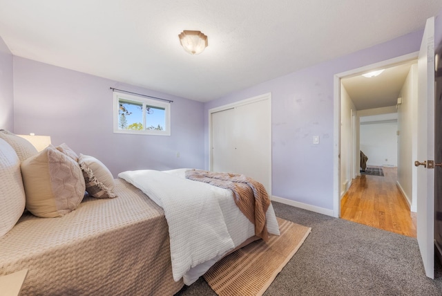 carpeted bedroom featuring baseboards and a closet