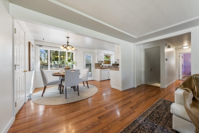 dining space with light wood-style floors, baseboards, and a notable chandelier