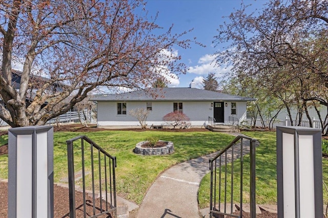 back of property with a lawn and fence
