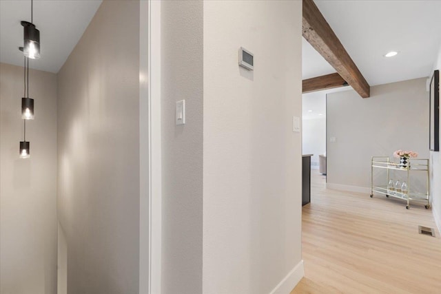 hall featuring light wood-type flooring, baseboards, beam ceiling, visible vents, and recessed lighting