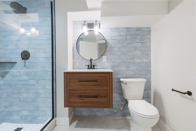 full bathroom featuring toilet, tile patterned floors, vanity, baseboards, and tiled shower