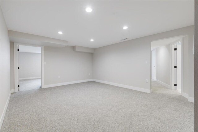 finished basement featuring light carpet, visible vents, and recessed lighting