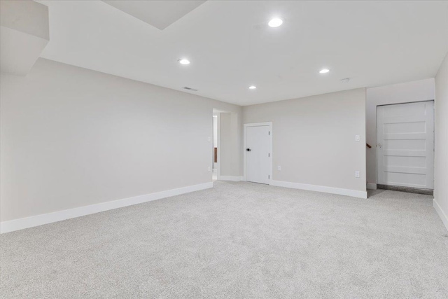 spare room featuring recessed lighting, baseboards, and light carpet
