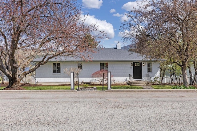 ranch-style house featuring brick siding