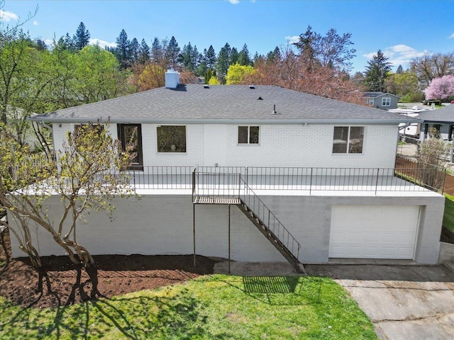 rear view of house featuring a chimney, concrete driveway, brick siding, an attached garage, and stairway