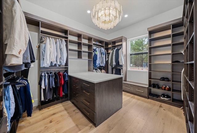 27603 N Bruce Rd, Chattaroy, WA 99003 - walk in closet with light wood-style floors and a chandelier