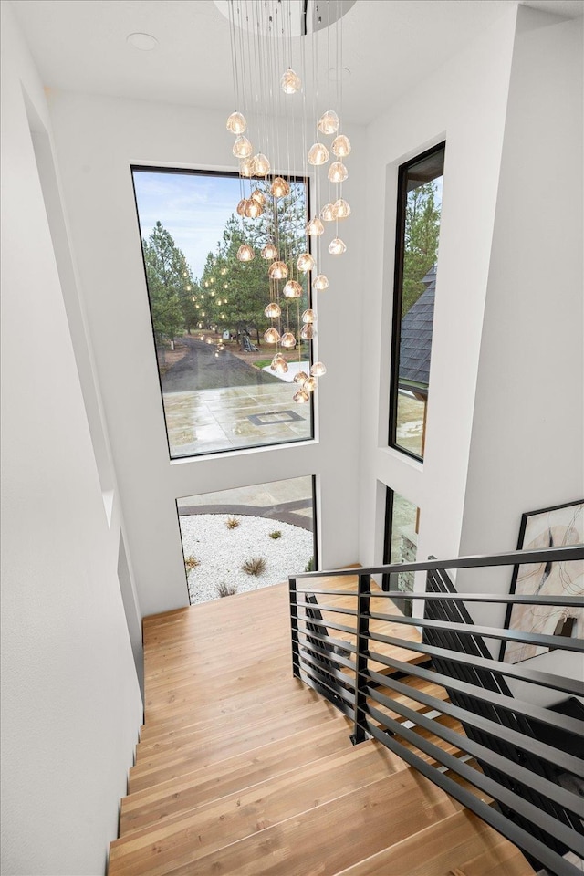 27603 N Bruce Rd, Chattaroy, WA 99003 - stairs featuring a chandelier and wood finished floors