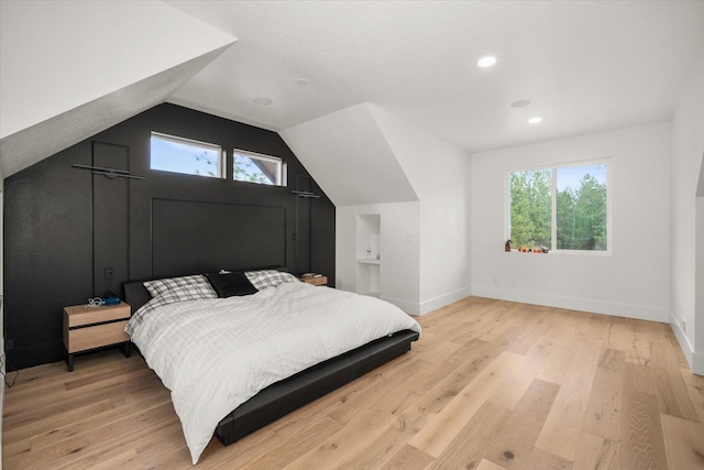 27603 N Bruce Rd, Chattaroy, WA 99003 - bedroom with baseboards, lofted ceiling, multiple windows, and light wood-style flooring