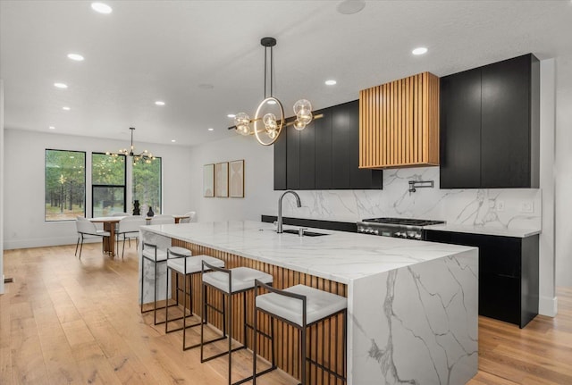 27603 N Bruce Rd, Chattaroy, WA 99003 - kitchen featuring light wood-style flooring, a sink, a notable chandelier, dark cabinetry, and modern cabinets