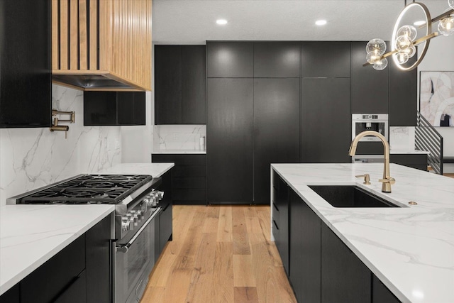 27603 N Bruce Rd, Chattaroy, WA 99003 - kitchen with dark cabinets, modern cabinets, a sink, light wood-style floors, and high end range