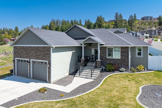 2521 S Vera Crest Ct, Spokane Valley, WA 99037 - craftsman house featuring an attached garage, driveway, roof with shingles, and stone siding