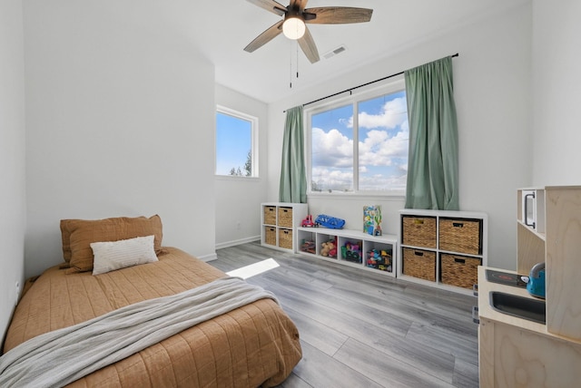 bedroom featuring visible vents, light wood-style floors, and ceiling fan