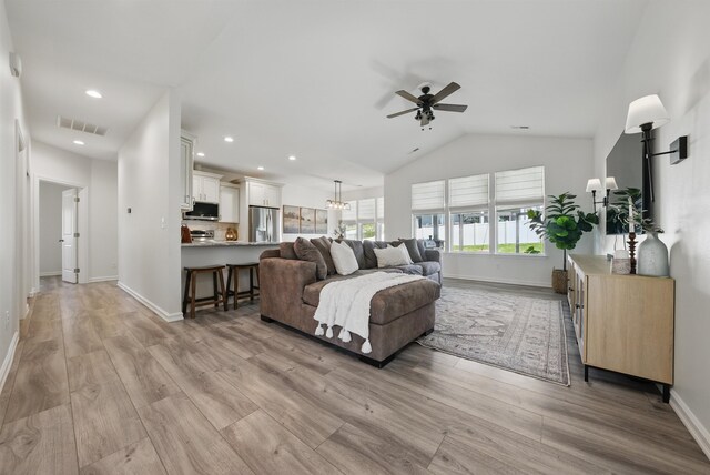 living room featuring ceiling fan, baseboards, and visible vents