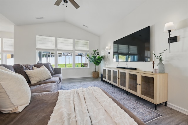 living area featuring lofted ceiling, a wealth of natural light, a ceiling fan, and wood finished floors