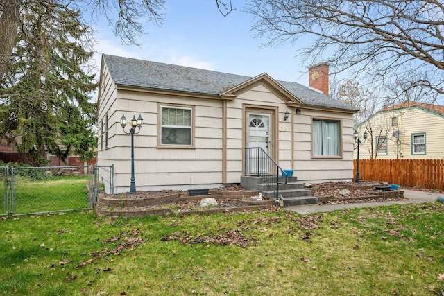 view of front of home with fence, a chimney, a shingled roof, and a front lawn