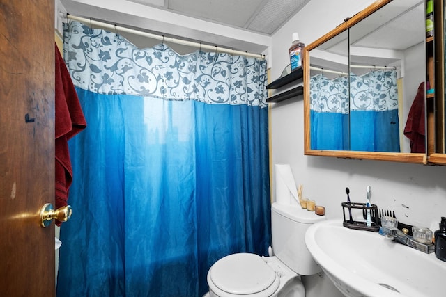 bathroom featuring a sink, a shower with curtain, and toilet