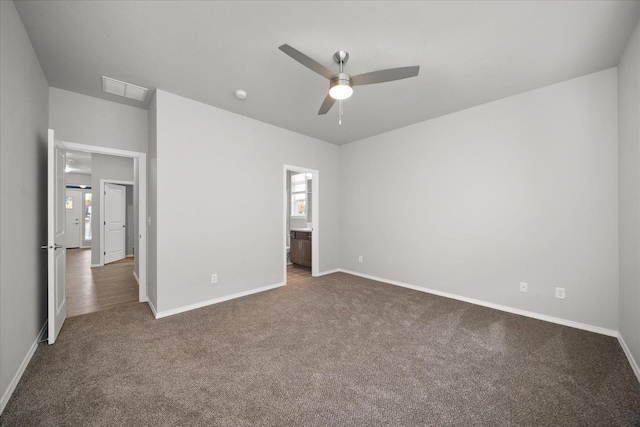 unfurnished bedroom featuring ensuite bath, visible vents, baseboards, multiple windows, and carpet floors