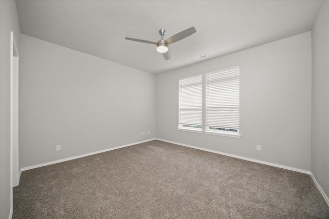 carpeted spare room featuring ceiling fan, visible vents, and baseboards