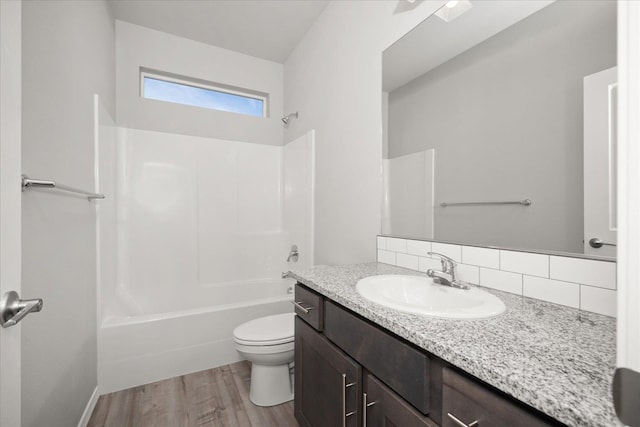 full bath with toilet, shower / bath combination, wood finished floors, vanity, and backsplash