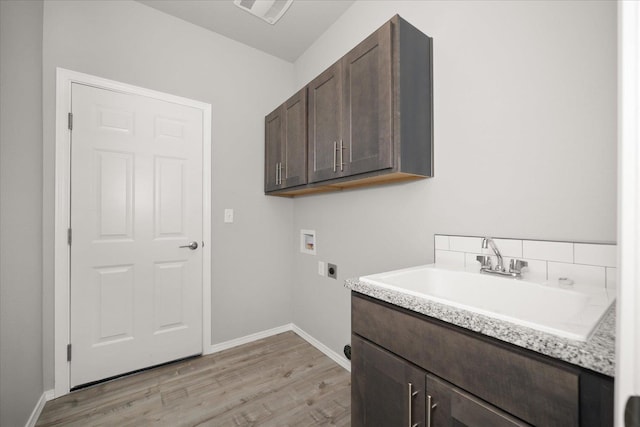 laundry room featuring hookup for a washing machine, electric dryer hookup, light wood finished floors, a sink, and visible vents