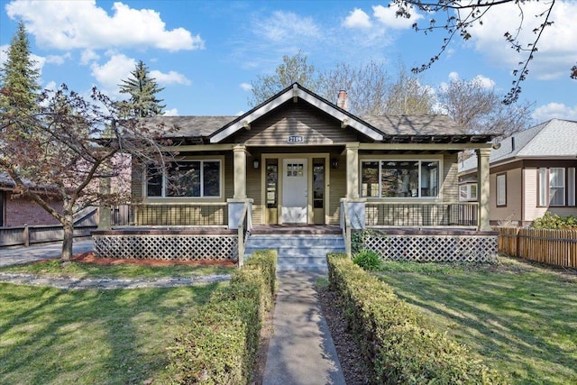 view of front facade featuring covered porch, fence private yard, and a front yard