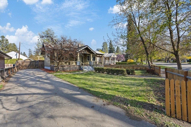 view of front of home featuring fence, a porch, and a front lawn