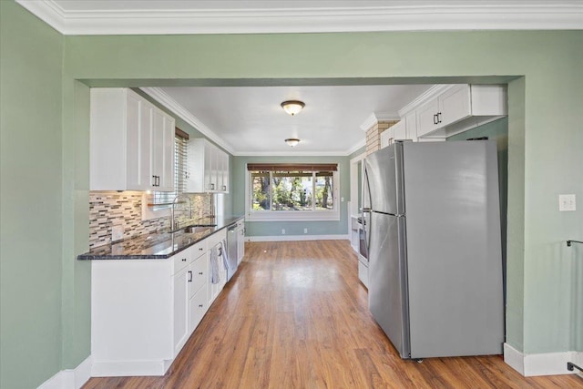 kitchen featuring baseboards, appliances with stainless steel finishes, white cabinetry, and a sink