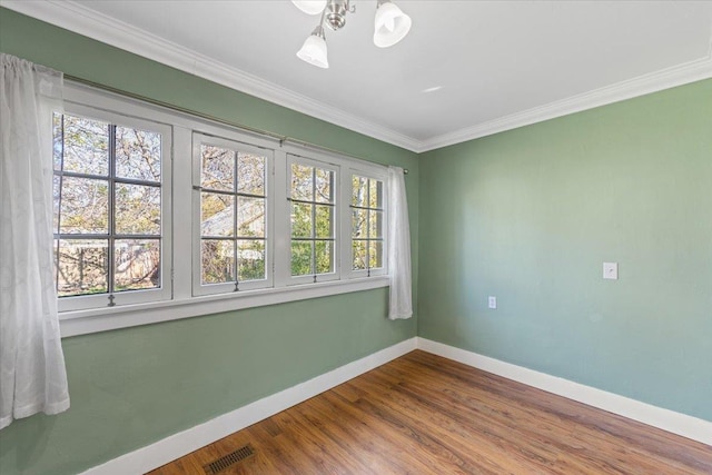unfurnished room with crown molding, visible vents, dark wood-style floors, baseboards, and an inviting chandelier