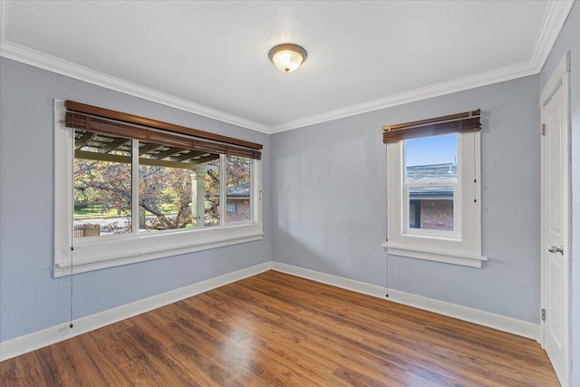 spare room featuring ornamental molding, wood finished floors, and baseboards