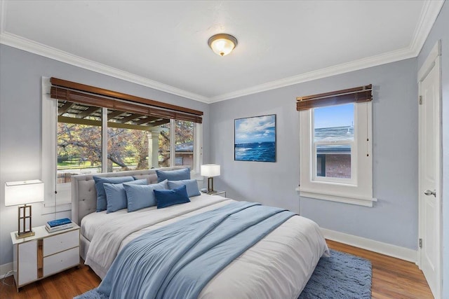 bedroom featuring wood finished floors, ornamental molding, and baseboards