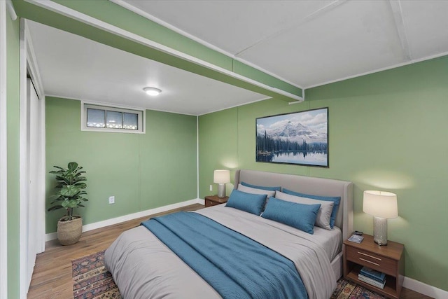 bedroom featuring baseboards and wood finished floors