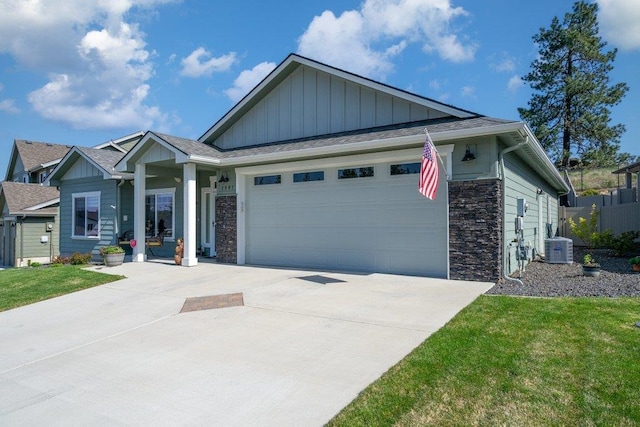 view of front facade with board and batten siding, driveway, stone siding, central AC, and an attached garage