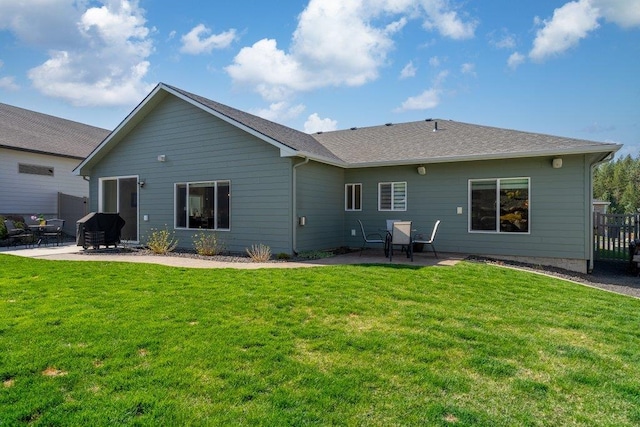 rear view of house with a patio and a yard