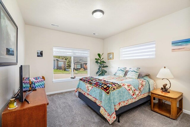 bedroom with baseboards, visible vents, and carpet flooring